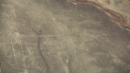 Fototapeta premium Aerial view of ancient Nazca Hummingbird geoglyph in Peru with copy space