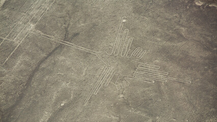Fototapeta premium Aerial view of ancient Nazca Hummingbird geoglyph in Peru with copy space