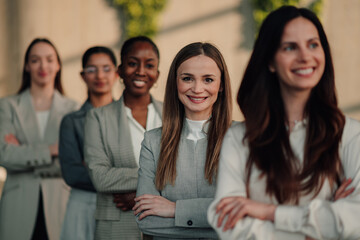 Fototapeta premium Diverse businesswomen team standing in office with arms crossed, smiling, representing leadership, success, and empowerment