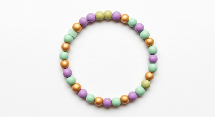Fototapeta premium Handmade pastel beaded bracelet with gold accents arranged in a circle on a clean white background