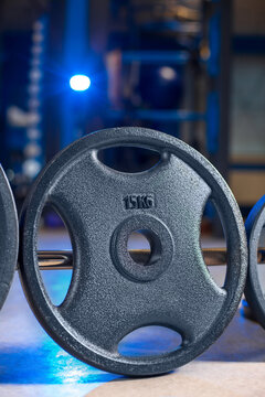 20 kg weight plate on barbell close up in gym, heavy strength training equipment