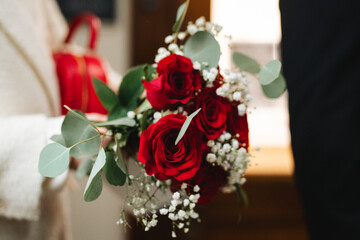 Obraz premium Beautiful bouquet of red roses with eucalyptus and baby breath