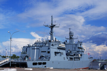 Fototapeta premium A warship moored on the embankment in the city center, navy, naval artillery, military weapons.