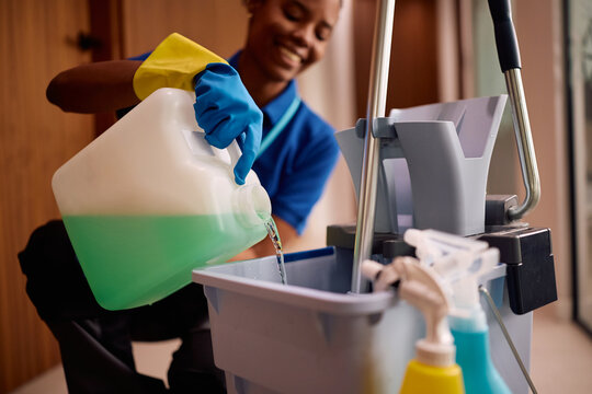 Close up of professional cleaner using liquid detergent for floor mopping.