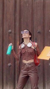 Joyful university student dancing on city street. door, Background,