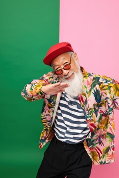 Older man dabbing and smiling in colorful studio backdrop