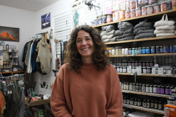 Fototapeta premium Independent shop owner and seller in one, serving a customer inside a small family-run household goods shop, casual domestic atmosphere, soft overhead light, real unpolished look
