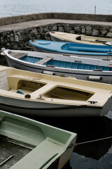 Fototapeta premium Boats, dock and water in harbor, colorful vessels moored at pier, peaceful scene of leisure and relaxation, summer day by the coast, marine lifestyle and tranquility.