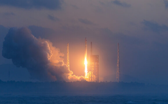 Rocket launch with flame and smoke against cloudy sky at dusk with spectacular ignition flare