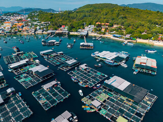 Floating fish farms with boats in coastal village harbor, Aerial view Nha Trang Vietnam © Parilov