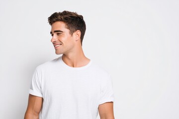 Obraz premium Head and shoulders portrait of a stylish young man in a tee, looking to the side with a confident, relaxed smile