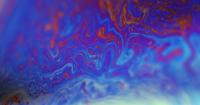 Spherical abstraction of iridescent blue, yellow and red colors with soft focus. Rainbow multilayer film. Natural environment.