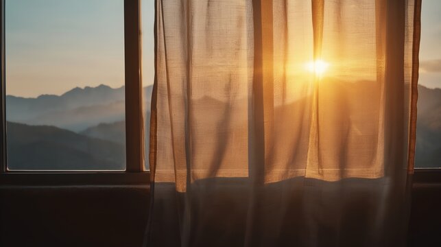Window curtain allows golden sunrise to cast gentle glow over mountain landscape
