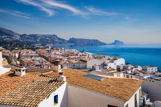 Panoramic view of Altea with tiled roofs, Mediterranean sea and Penon de Ifach.