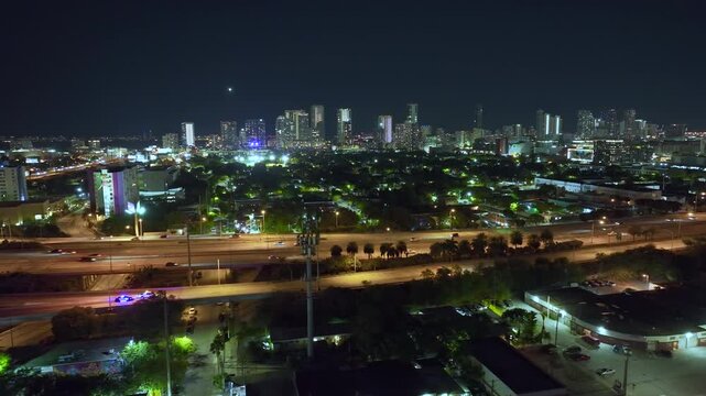 Aerial view of American freeway at night with fast driving cars and trucks in Miami city, Florida. View from above of USA transportation infrastructure.