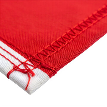 Red fabric texture with overlock stitching, macro view of textile seam and white border, industrial sewing craftsmanship on cotton material isolated on White Background