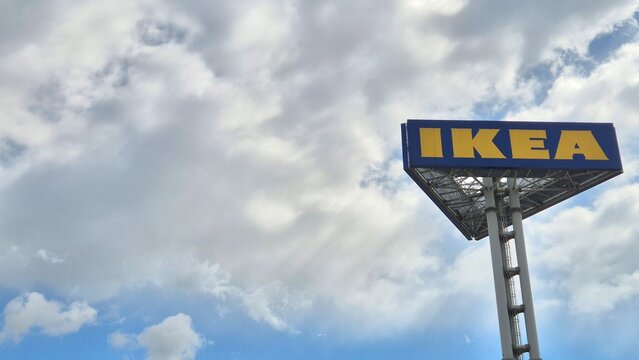 An outdoor shot of a high IKEA pylon sign with its iconic blue and yellow logo against a bright, cloudy sky backdrop taken on April 8, 2026 in Bucharest, Romania.
