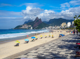 Ipanema beach with mosaic of sidewalk and mountain Dois Irmao (Two Brother) in Rio de Janeiro, Brazil. Ipanema beach is the most famous beach of Rio de Janeiro, Brazil. Cityscape of Rio de Janeiro.