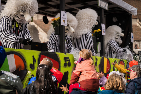 Basel, Switzerland - 10 March 2025: View of whimsical Fasnacht parade floats with masked figures amidst a flurry of confetti, enchanting onlookers in a vibrant spectacle.