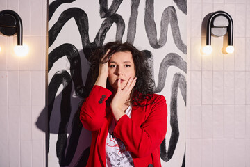 Fototapeta premium Creator dressed in striking crimson attire captured in mural setting