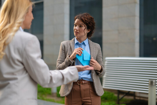Business woman secretly taking an envelope, demonstrating corruption