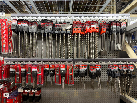 Prosper, Texas, USA - April 1st, 2026: Extensive collection of Milwaukee SDS Plus and SDS Max masonry drill bits and chisels displayed on metal shelving in The Home Depot