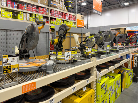 Prosper, Texas, USA - April 1st, 2026: Selection of Ridgid and DeWalt sliding compound miter saws arranged on long metal shelving unit in The Home Depot