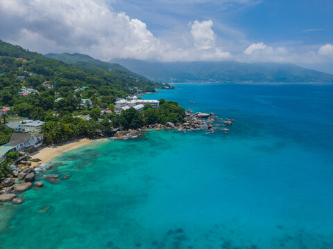 Aerial view of the turquoise waters contrasting with the lush greenery of the coastline, Vista do Mar, Mahe island, Seychelles.