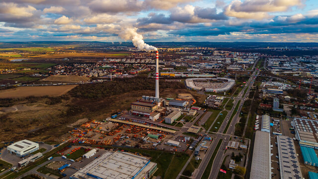 Aerial view of the stark chimney stack contrasting against the industrial landscape, its smoke a plume against the sky, 32 Prumyslova, Praha 10, Czechia.