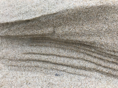 View of windswept sand dunes creating rhythmic patterns of light and shadow, crafting a textured landscape of nature's artistry, De Cocksdorp, Noord-Holland, Netherlands.