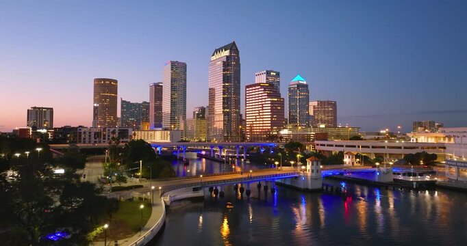Tampa city in Florida with highway traffic on bridge and skyscraper buildings in downtown district. American megapolis with business financial district at night.
