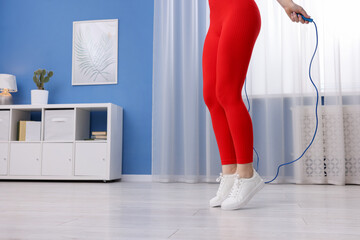 Woman training with skipping rope indoors, closeup. Space for text © New Africa