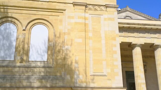 Historic stone building facade with classical columns in sunlight