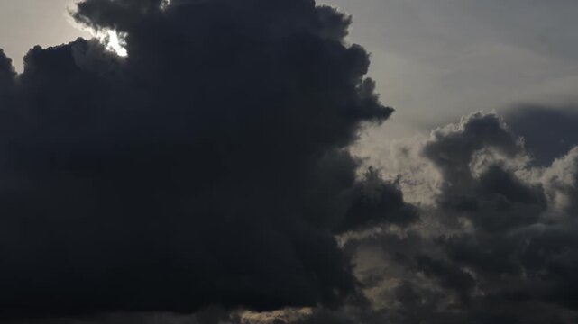 Dramatic dark clouds with bright sunlight breaking through.time lapse