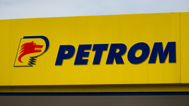 Piatra Neamt, Romania - Aug 22, 2025: A close-up shot of the Petrom logo on a vibrant yellow sign, featuring the company name in bold blue letters and a stylized red wolf head.
