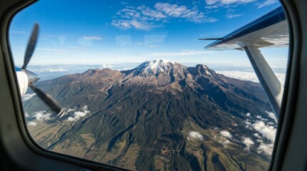 Aerial view of Mount Kilimanjaro, showcasing snow-capped peaks, rugged terrain, and panoramic landscapes.