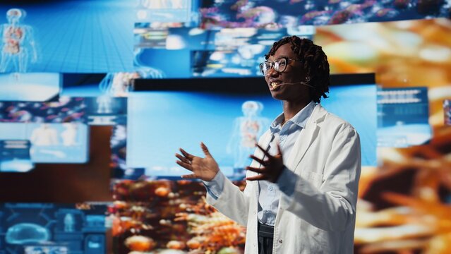 Cheerful scientist speaking in mic, excited to present future of medical field. Jolly biomedical expert talks about futuristic high tech antiviral strategies during medical conference, camera A