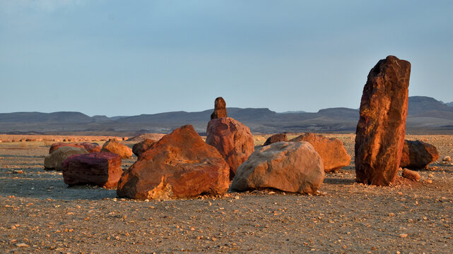 Red Iron Sandstone Boulders on Makhtesh Ramon Crater Floor at Golden Hour, Negev Desert Israel travel photo with copy space