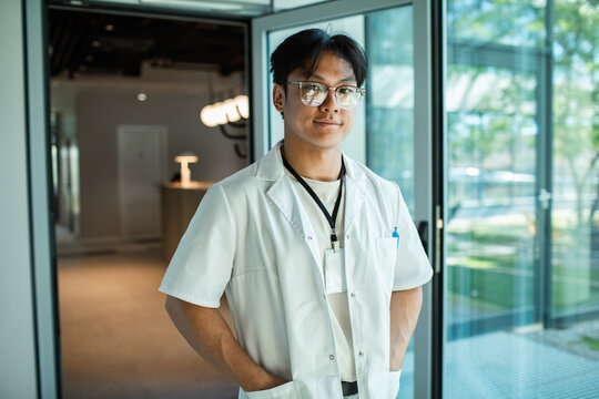 Young doctor with id badge in modern clinic lobby