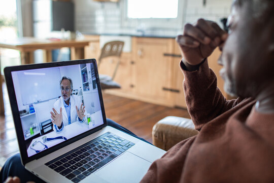 Patient consulting doctor online at home via laptop