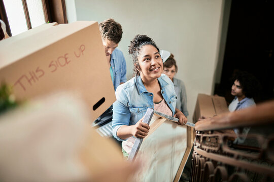 Young adults moving boxes up apartment stairs