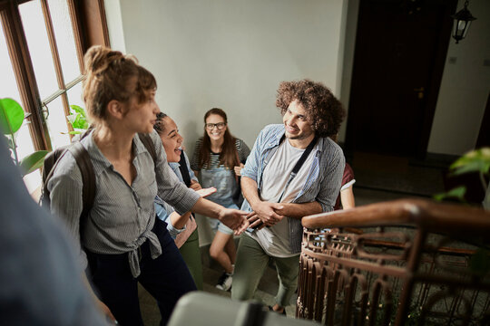 Smiling college students chatting on a university stairwell