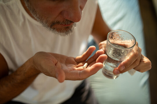 Man taking pill with water at home
