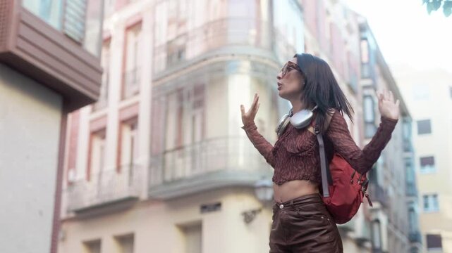 Happy female traveler dancing in the streets of Madrid