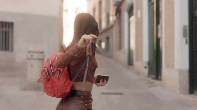 Happy young woman dancing while walking in a city street