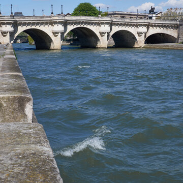Pont Neuf bridge over Seine in spring with rippling river and stone quay