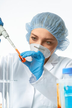 Woman pipetting with micropipette transferring orange reagent into microtube in lab