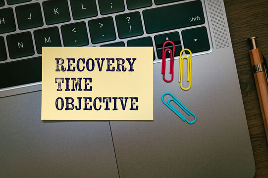 Modern technology concept of Recovery Time Objective on sticky note with laptop, clips. Digital innovation and connectivity visualization.