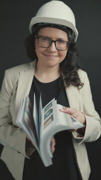 Smiling female engineer flipping through technical manual