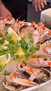 preparazione crudo di mare in un piatto con ghiaccio sul bancone di una pescheria